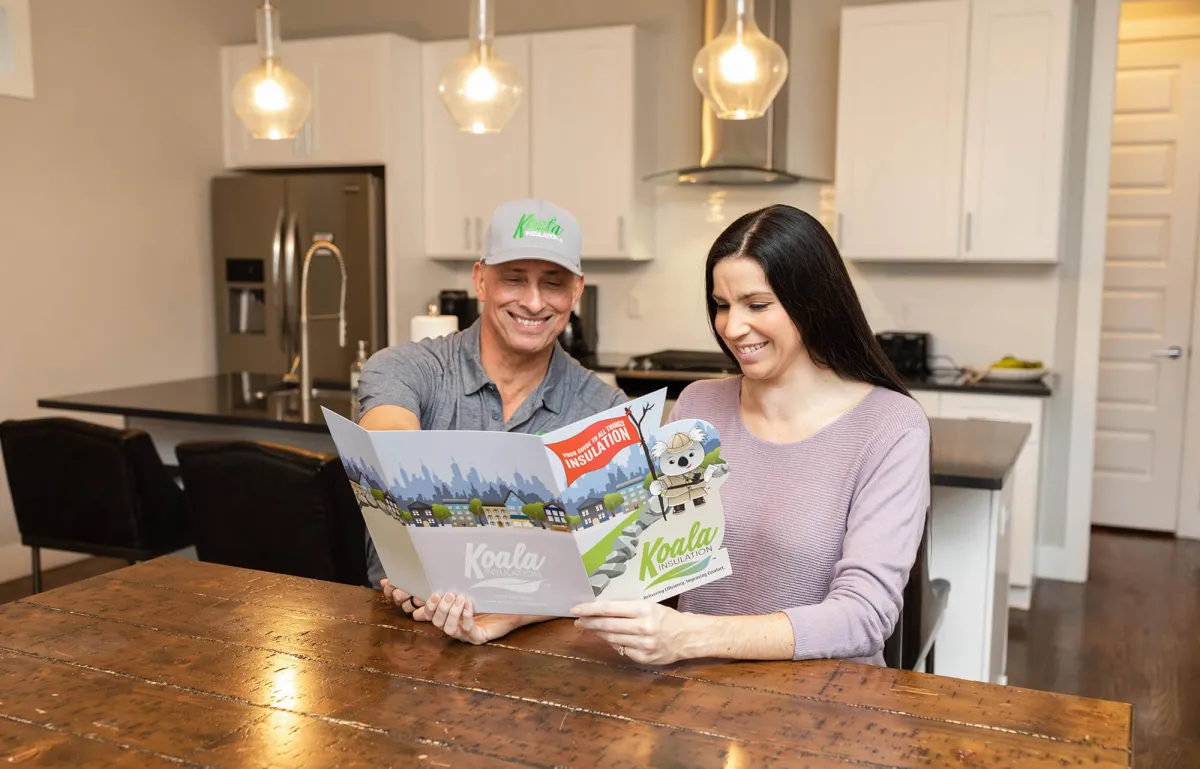 Koala Insulation professional reviewing an insulation guide with a homeowner
